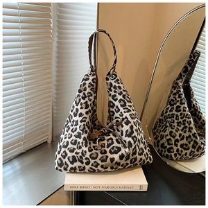 Detail der Hobo-Schultertasche mit Leopardenmuster, brauner Lederschleife und Emblem