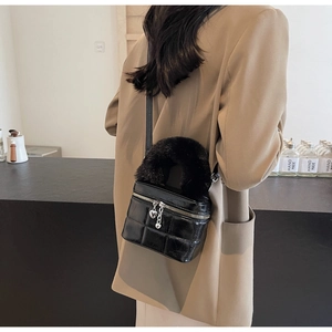 Rückansicht eines Models mit gesteppter Mini-Tasche, Pelzgriff und Herz-Anhängsel