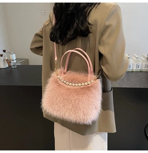 Sac à main rose en fausse fourrure avec perles porté à l'épaule par un mannequin