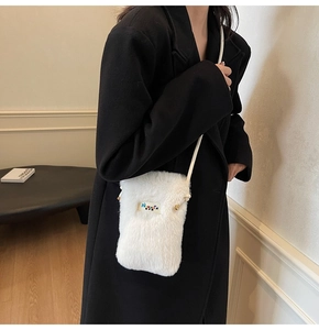 Modèle portant un sac bandoulière en fausse fourrure blanche duveteuse très élégant
