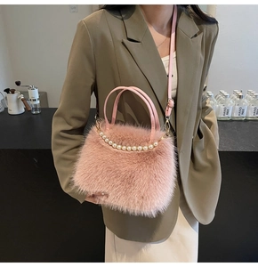 Détail d'un sac à main rose en peluche avec décoration élégante en perles blanches