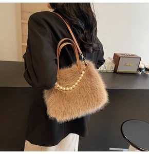 Détails de la main d'un sac en fausse fourrure marron avec perles et bandoulière