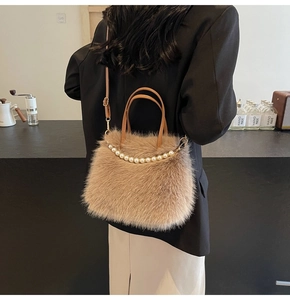 Sac à main peluche marron avec perles porté par un mannequin en blazer noir
