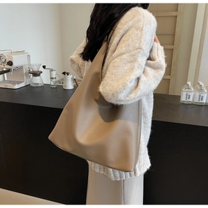Litchi texture PU leather tote bag shown in use by a model in a cafe setting