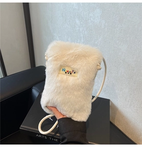 Vue détaillée du sac bandoulière en peluche blanche avec étiquette Nakalin et sangle