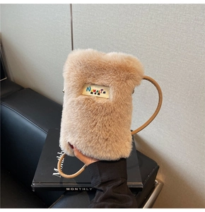 Gros plan sur la texture douce en peluche et le logo tissé du sac à bandoulière