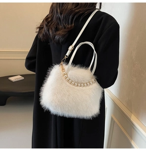 Détail du sac à main en fausse fourrure blanche avec poignée en perles et métal