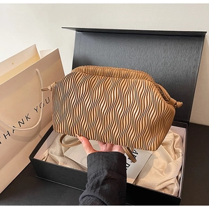 Detail der hellbraunen Faltentasche in einer schwarzen Geschenkbox auf Seidenfutter