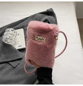 Détail d'un sac bandoulière en fausse fourrure rose avec broderie NAKALIN et ferrures dorées