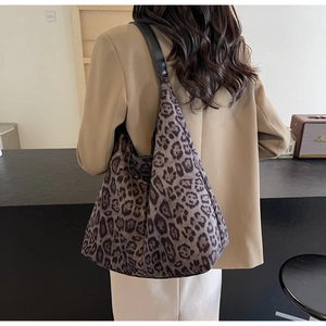 Vue détaillée d'un grand sac cabas à imprimé léopard avec des anses en cuir noir