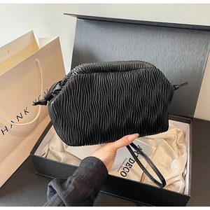 Detail der schwarzen Cloud-Bag mit Wellenfalten und elegantem Armband für den Abend