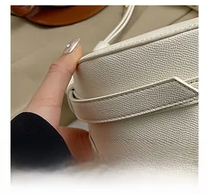 Dettaglio ravvicinato delle cuciture di precisione e della pelle Saffiano di una borsa bianca