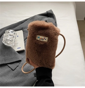 Détail du mini sac bandoulière en peluche marron avec fausse fourrure et étiquette logo