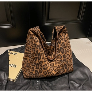 Détail du sac cabas léopard avec anses en cuir marron foncé et design de grande capacité