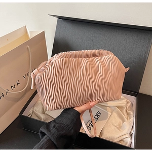 Nahaufnahme der rosa Faltenhandtasche mit vertikalen Falten in schwarzer Geschenkbox