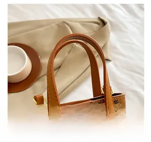 Détail de la pochette téléphone marron avec motif ours et crochets dorés en métal