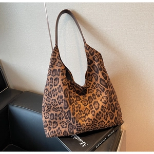 Chic leopard print tote bag with brown straps showcased in a stylish interior setting