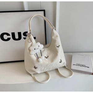 Detail view of cream white versatile bag featuring silver butterflies and cloud charm