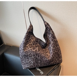 Détail du sac cabas à imprimé léopard gris posé élégamment sur un canapé en cuir