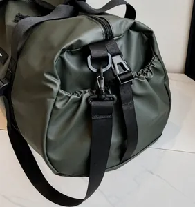 Detail view of the green Oxford travel bag showing adjustable shoulder strap and side pocket