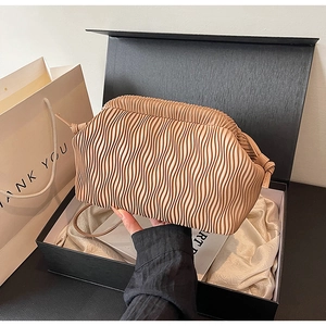 Detailansicht der beigen Falten-Cloud-Tasche in Geschenkbox mit Satinfutter und Beutel