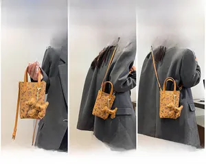Petit sac marron à motif ours présenté en trois modes : à main, à l'épaule et en bandoulière