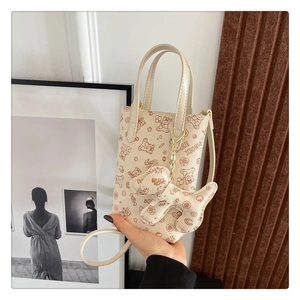 Détail du mini sac à bandoulière avec imprimé ours et breloque chien assortie