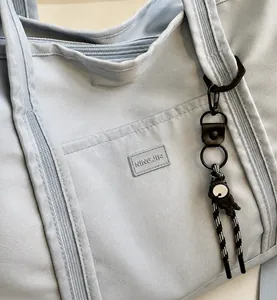 Detail of light blue travel tote showing NINGJIG logo and astronaut charm decoration