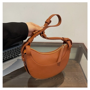 Dettaglio della tracolla regolabile e della pelle martellata della borsa marrone