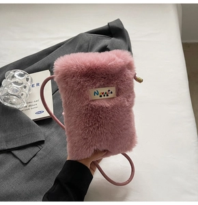 Détail du petit sac bandoulière en fausse fourrure rose avec étiquette Nakalin sur tissu