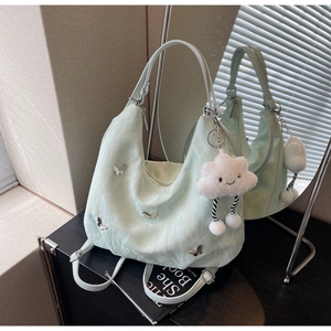 Detail of light green hobo bag with silver butterflies and cloud plush charm