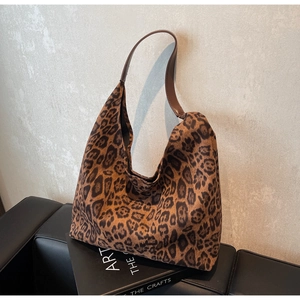 Détail du sac cabas imprimé léopard avec une bandoulière en cuir marron de haute qualité