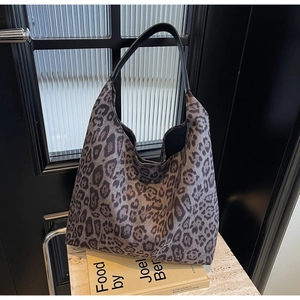 Détail d'un grand sac cabas à imprimé léopard posé sur un support en pierre chic
