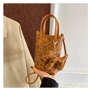Détail du sac de téléphone marron avec imprimés animaux et pendentif chiot amovible
