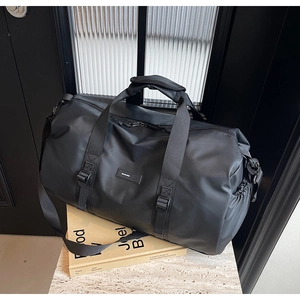 Detail of waterproof black nylon travel bag with reinforced handles and side pocket