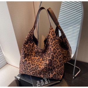 Vue détaillée du sac cabas imprimé léopard avec anses en cuir marron et texture du tissu