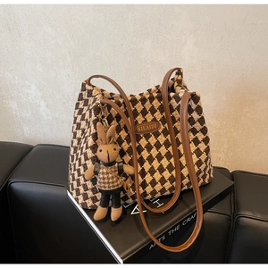 Detail of vintage diamond pattern tote bag with leather straps and cute rabbit charm