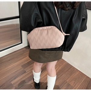 Detail der hellrosa gefalteten Cloud-Tasche mit vertikaler Ledertextur auf einer Jacke