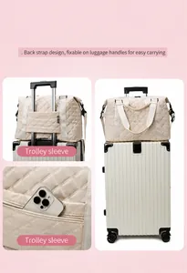 Detail of quilted travel bag with trolley sleeve and side zipper pocket on a pink background