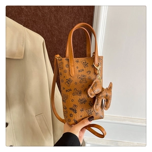 Détail d'un mini sac cabas marron avec imprimés panda et charmant pendentif chien
