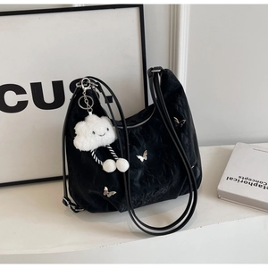 Close-up of black pleated hobo bag with silver butterfly and plush cloud charm