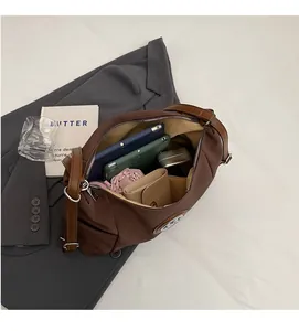 Interior view showing large capacity brown nylon tote bag with tablet and daily essentials