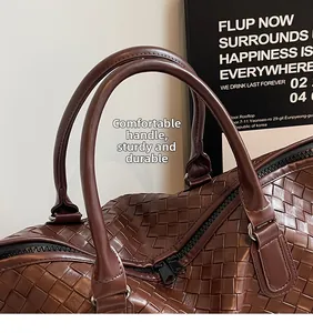 Detailed close-up of dark brown woven handle and texture on a stylish travel duffel bag