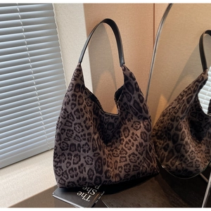 Détail du grand sac cabas à imprimé léopard avec bandoulière en cuir noir dans un décor doux