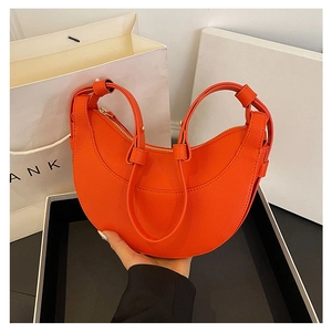 Dettaglio della borsa a mezzaluna arancione vivace con trama incrociata e zip in metallo