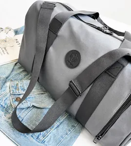 Detalle del bolso de viaje en nailon impermeable con logo y herrajes negro mate