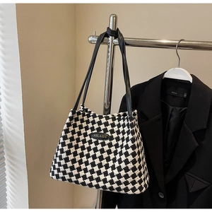 Detail of checkered tote bag with AILAIDI logo displayed on a minimalist hanger