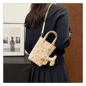 Vue détaillée d'un mini sac beige avec motifs oursons et pendentif chien mignon