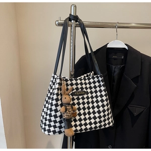 Detail of tweed checkerboard tote bag with AILAIDI logo and cute rabbit charm pendant