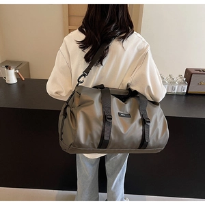 Detail of high-capacity oxford travel bag with wide straps and drawstring side pockets